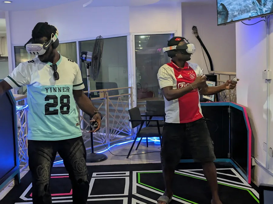 Two players sharing a free-roam multiplayer VR Arena session at Player One Game Cafe