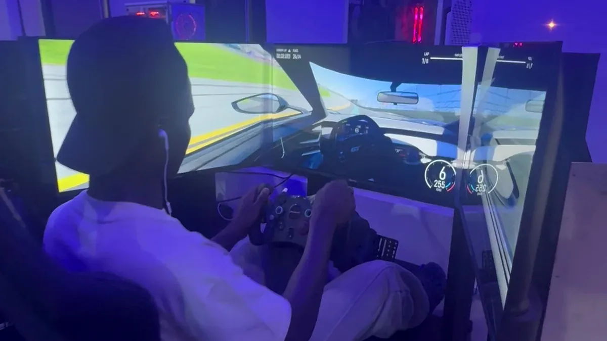 Guest racing on Player One's triple-screen simulator at Victoria Island